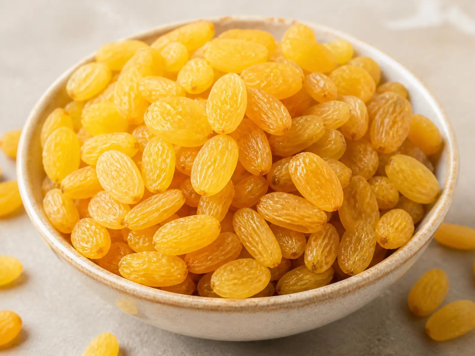 Bright golden yellow Indian raisins heaped in a ceramic bowl